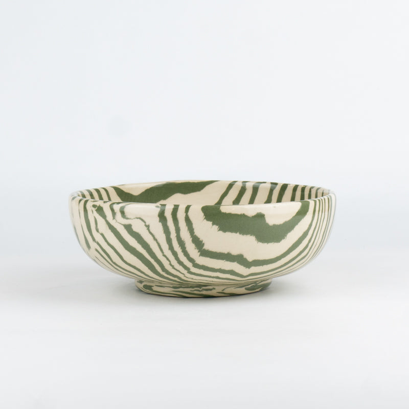 Ceramic bowl with green and white pattern on a white background
